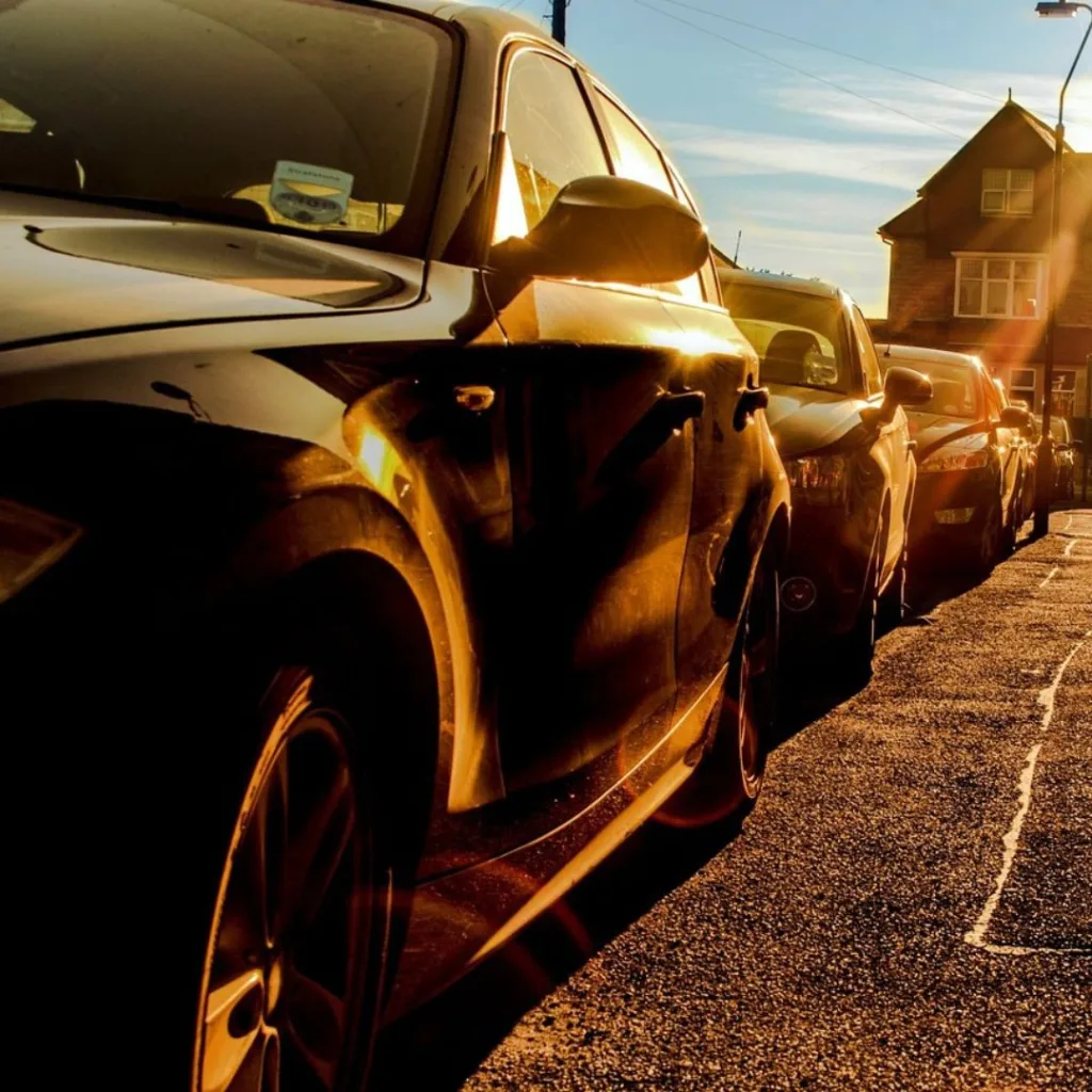 Cars parked up on a street in the sun