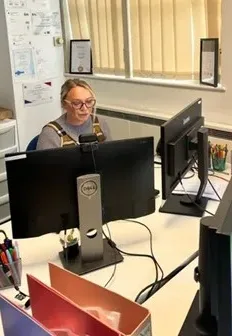 Nicole McGlade in the offices, sat behind a computer.