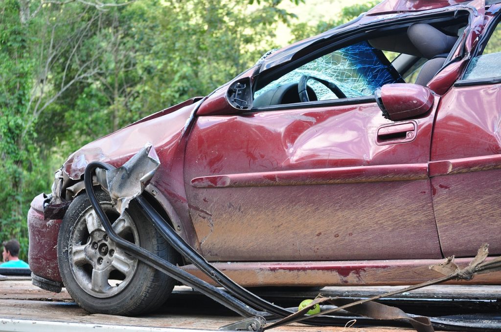 A crumpled car on the side of the road after a crash